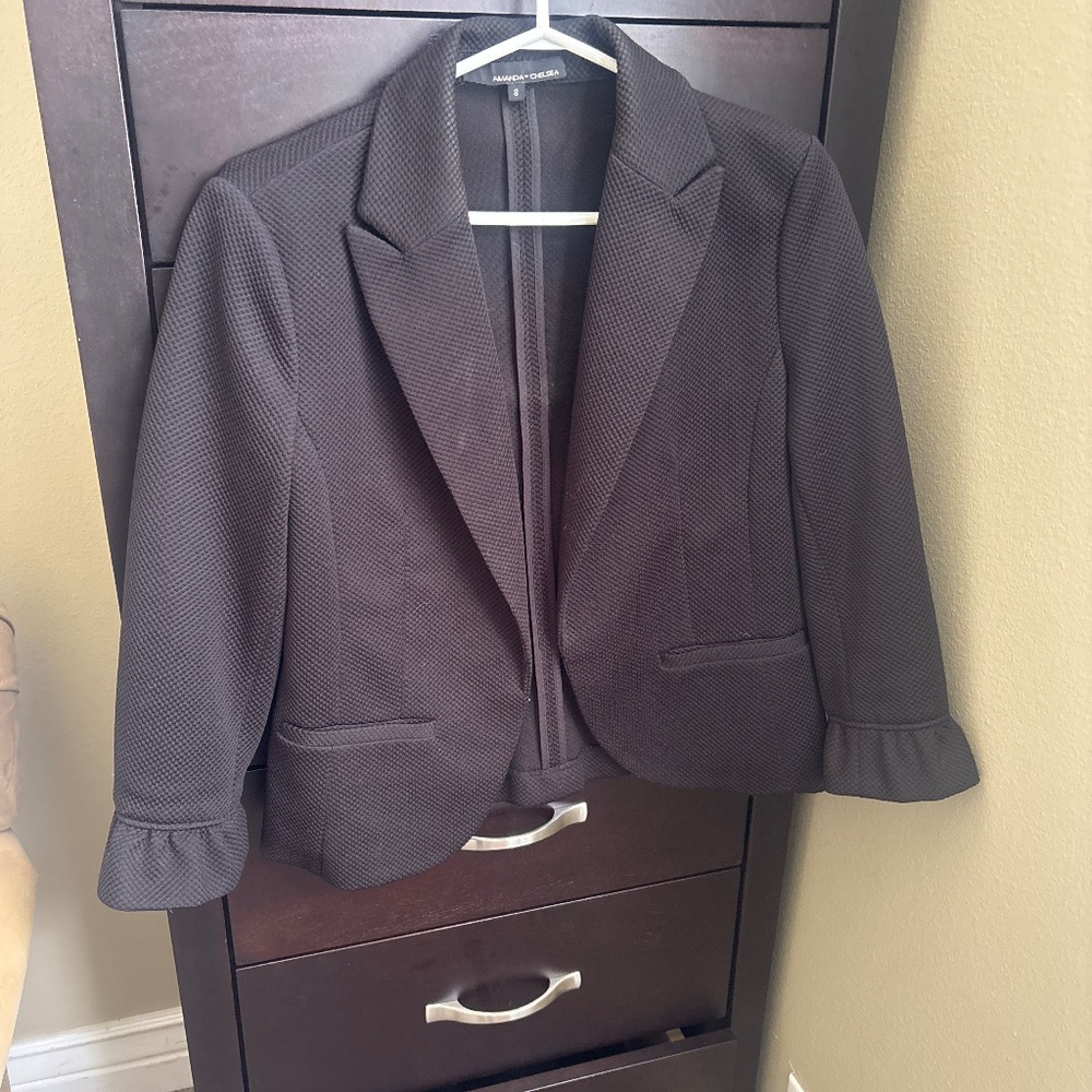 Black blazer with mid-length sleeves.